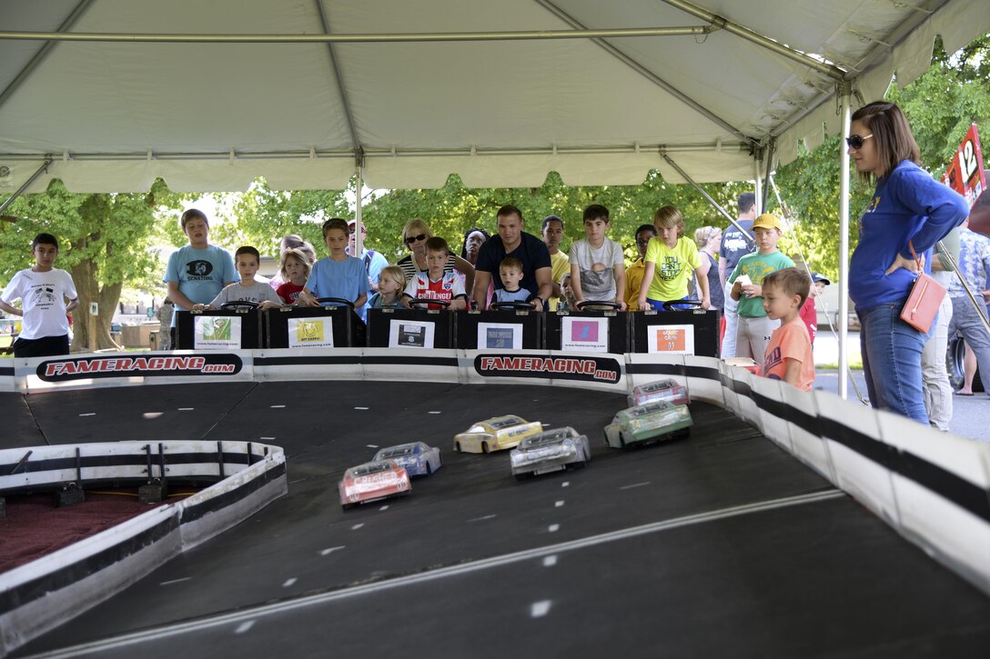 Members of Team Dover race remote control cars during the biannual NASCAR Social June 2, 2017, at Dover Air Force Base, Del. The event featured a miniature racetrack, a racecar simulator and two static racecar displays. (U.S. Air Force photo by Senior Airman Aaron J. Jenne)