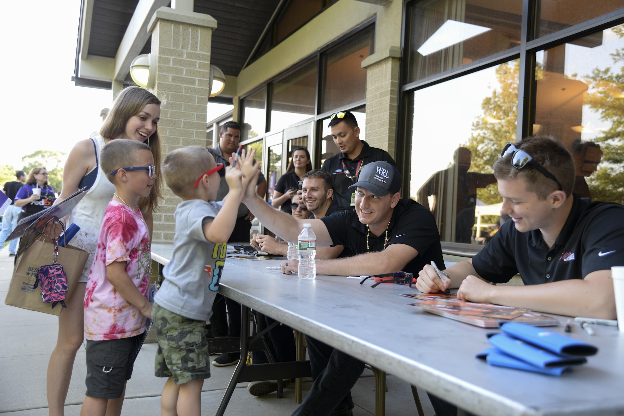 Michael McDowell, driver of the No. 43 car, high fives a young member of Team Dover during the biannual NASCAR Social June 2, 2017, at Dover Air Force Base, Del. McDowell and three other NASCAR drivers signed free autographs during the event. (U.S. Air Force photo by Senior Airman Aaron J. Jenne)