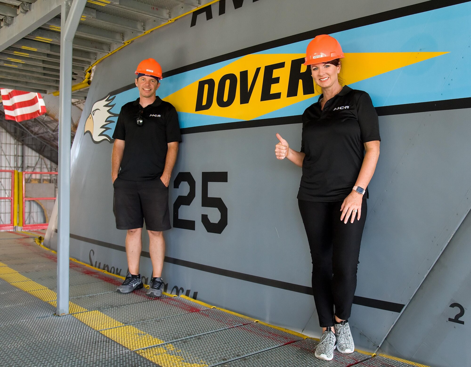 Jennifer Jo Cobb, NASCAR Camping World Truck Series driver for truck #10, right and Allen Chambers, Jennifer Jo Cobb Racing team member, left, stand by the C-5M Super Galaxy T-tail flash, May 31, 2017, at the C-5 Isochronal Inspection Dock on Dover Air Force Base, Del. Cobb and Chambers climbed up the T-tail to get a birds-eye view of a Super Galaxy undergoing maintenance. She and four members of the JJCR team toured the Air Traffic Control tower and the Isochronal Inspection Dock prior to race weekend at Dover International Speedway, Dover, Del., June 2-4, 2017. (U.S. Air Force photo by Roland Balik)