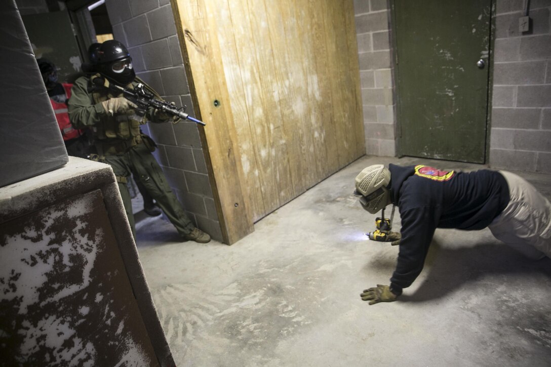 A Close Quarters Battle student instructs an occupant to “Get down, get down, get down, crawl to me!” while entering an enclosure to eliminate possible threats during the Operations Phase of CQB 2-17, May 31, aboard Naval Support Activity Northwest Annex ,Chesapeake, Va. Students engaged in a series of security alerts during the exercise, applying all the techniques they have throughout the course, before becoming Marine Corps Security Force Close Quarters Battle Team Members (8154s). (U.S. Marine Corps Photo by Sgt. Kayla D. Rivera/Released