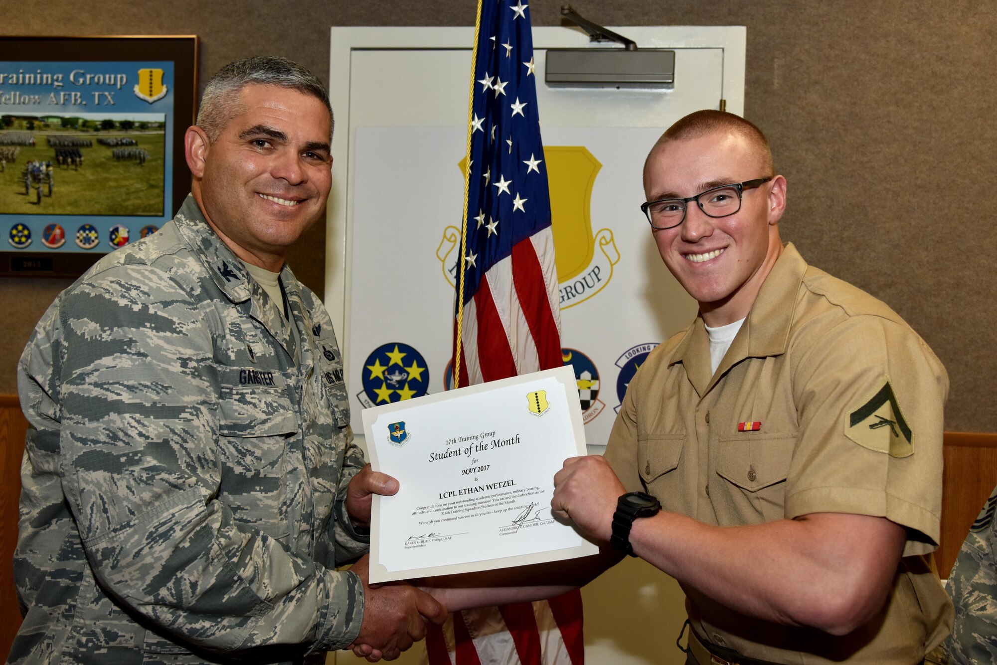 U.S. Air Force Col. Alex Ganster, 17th Training Group commander, presents the 316th Training Squadron Student of the Month award for May 2017 to Lance Cpl. Ethan Wetzel, 316th TRS student, in Brandenburg Hall on Goodfellow Air Force Base, Texas, June 2, 2017. (U.S. Air Force photo by Staff Sgt. Joshua Edwards/Released)