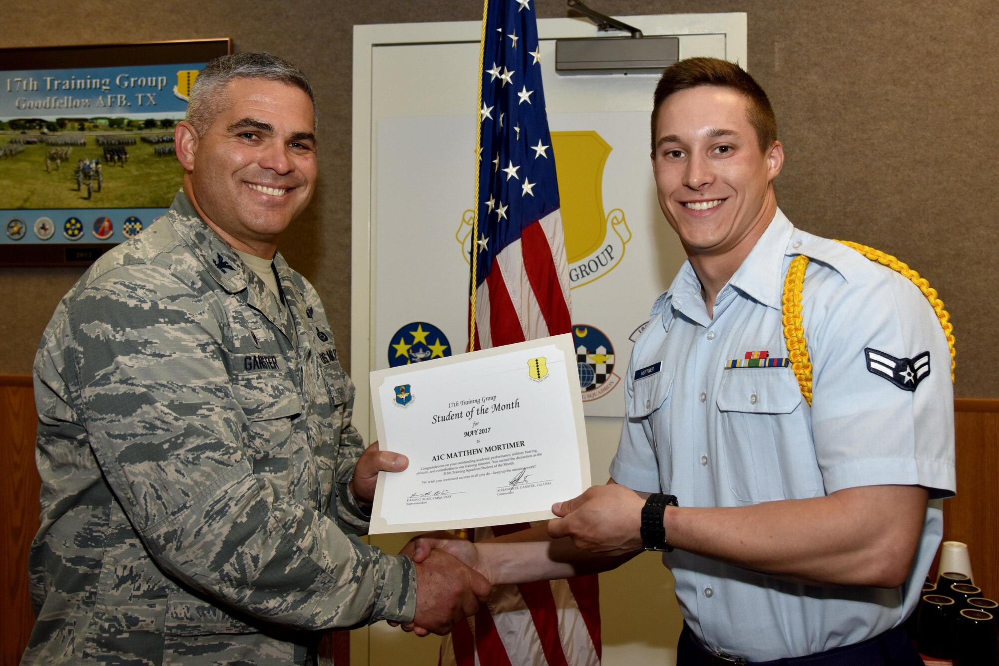 U.S. Air Force Col. Alex Ganster, 17th Training Group commander, presents the 315th Training Squadron Student of the Month award for May 2017 to Airman 1st Class Matthew Mortimer, 315th TRS student, in Brandenburg Hall on Goodfellow Air Force Base, Texas, June 2, 2017. (U.S. Air Force photo by Staff Sgt. Joshua Edwards/Released)