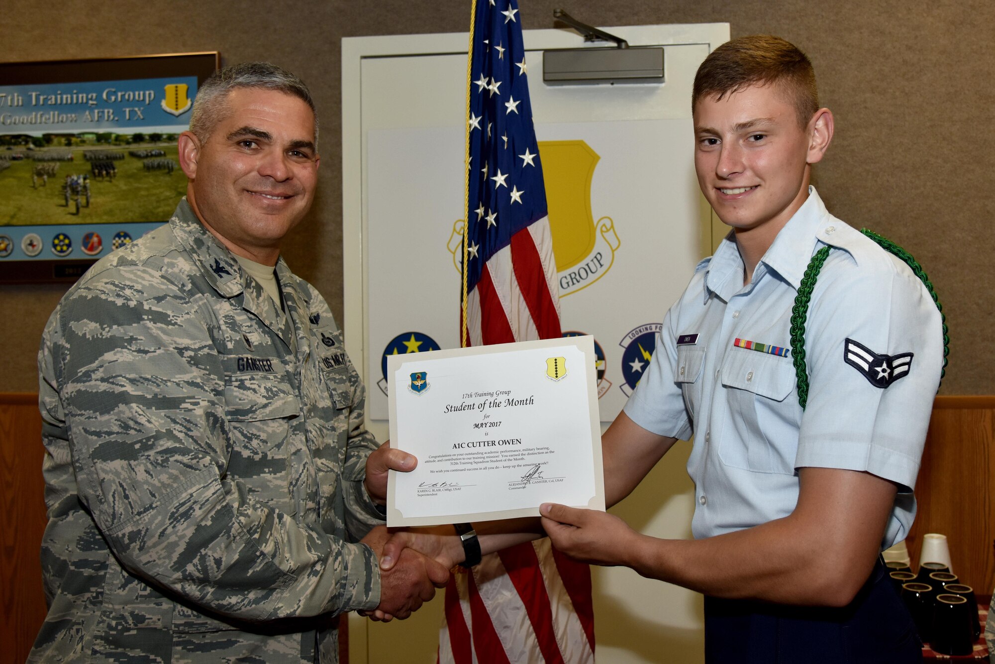 U.S. Air Force Col. Alex Ganster, 17th Training Group commander, presents the 312th Training Squadron Student of the Month award for May 2017 to Airman 1st Class Cutter Owen, 312th TRS student, in Brandenburg Hall on Goodfellow Air Force Base, Texas, June 2, 2017. (U.S. Air Force photo by Staff Sgt. Joshua Edwards/Released)
