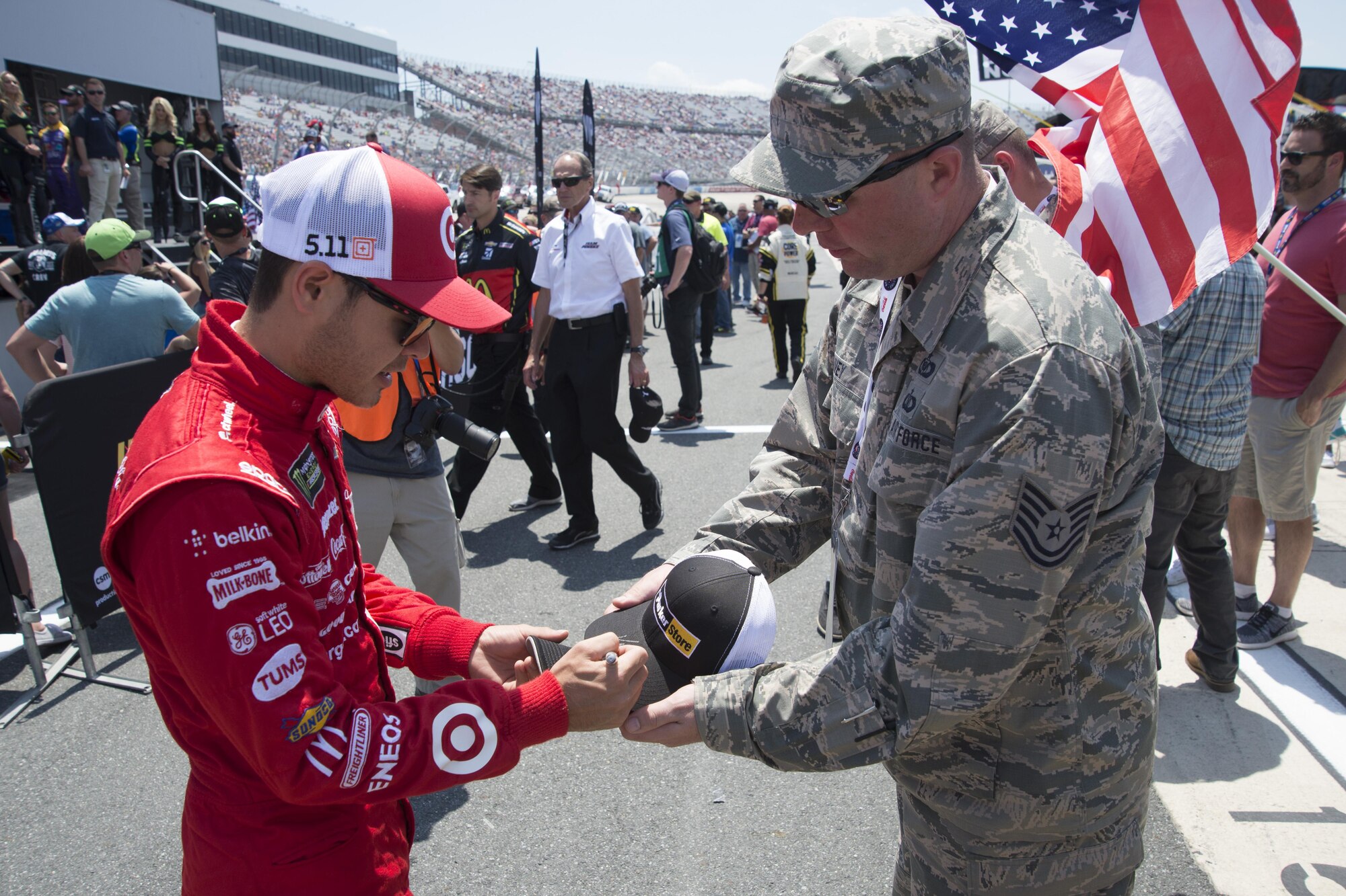 Kyle Larson, driver of the No.42  Target Chevrolet, signs Tech. Sgt. Jerry Ivey’s, 436th Airlift Wing command post NCO in charge C2 Operations, hat before the  start of the AAA 400 Drive for Autism Monster Energy race June 4, 2017, at Dover International Speedway, Dover, Del. Ivey was a part of the honorary pit crew member program, which provides Airmen the opportunity to interact with the drivers and pit crew members at the race. (U.S. Air Force photo by Staff Sgt. Jared Duhon)