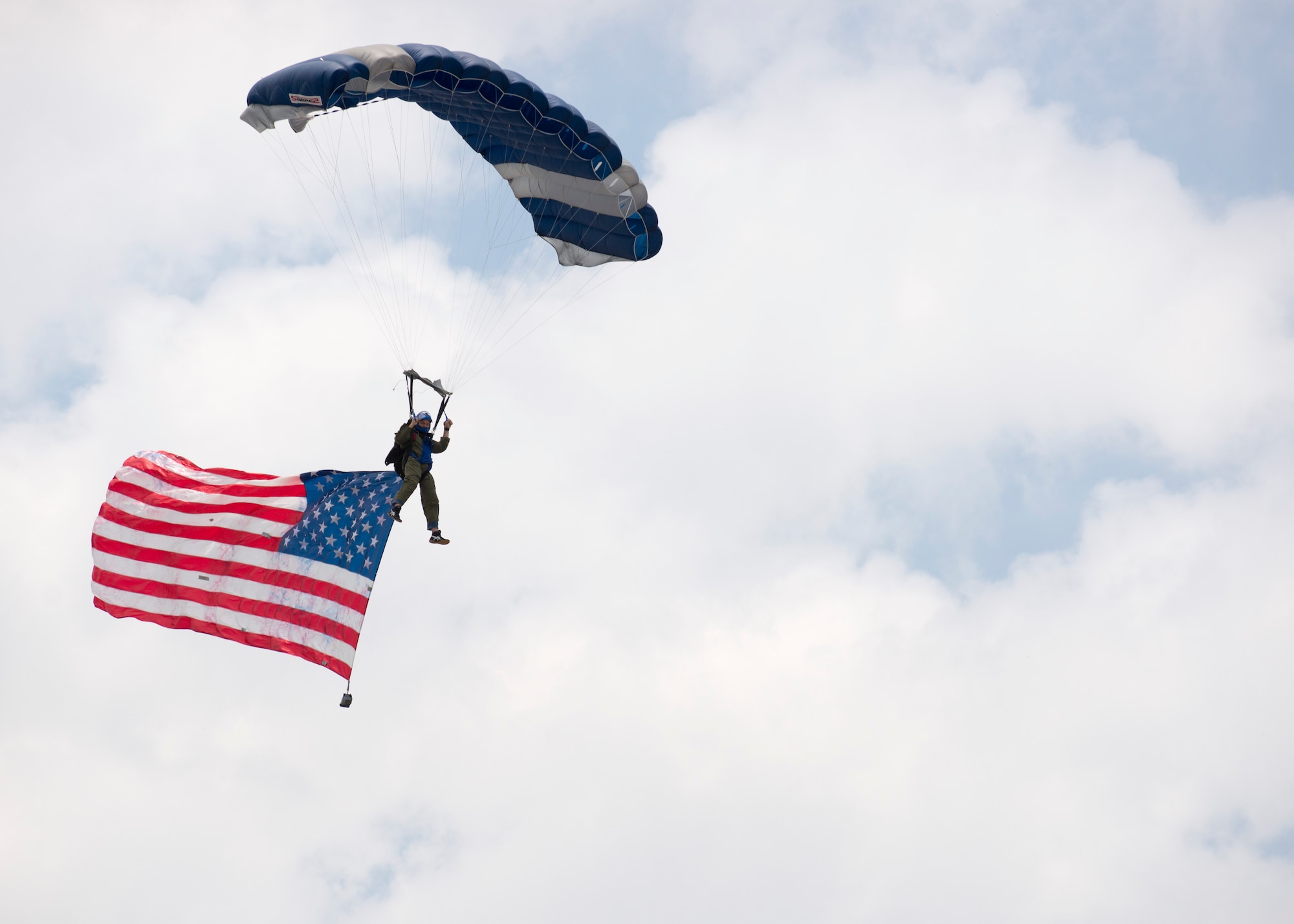 The Aerial Adventures parachute team floats down with the American Flag June 4, 2017, at Dover International Speedway, Dover, Del. The team was a part of the opening ceremony for the AAA 400 Drive for Autism Monster Energy race. (U.S. Air Force photo by Staff Sgt. Jared Duhon)