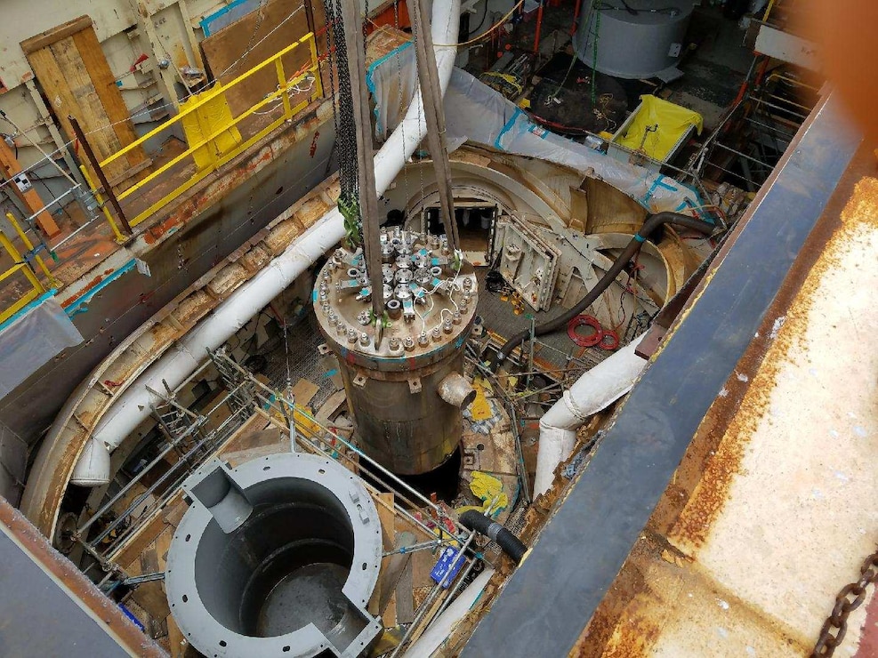 The Reactor Pressure Vessel is lifted from the Reactor Containment Vessel aboard the STURGIS to be placed in the specially designed container to its left for transport. The Reactor Pressure Vessel was safely transported to a disposal facility in June 2017 as part of the ongoing decommissioning of the MH-1A nuclear reactor aboard the STURGIS. The removal of the RPV means that approximately 98 percent of the radioactivity has been removed from the vessel.