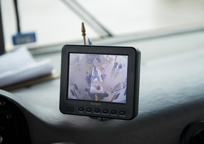 A backup camera on a military vehicle captures a “patient” being transferred by medical personnel from bus to C-130 aircraft as part of a joint service training exercise involving members from the 914th Aeromedical Staging Squadron and medical personnel from other branches of the military. Participants carry out simulated emergency scenarios to gain skills and experience that can be applied to real world situations. (U.S. Air Force photo by Tech. Sgt. Stephanie Sawyer) 