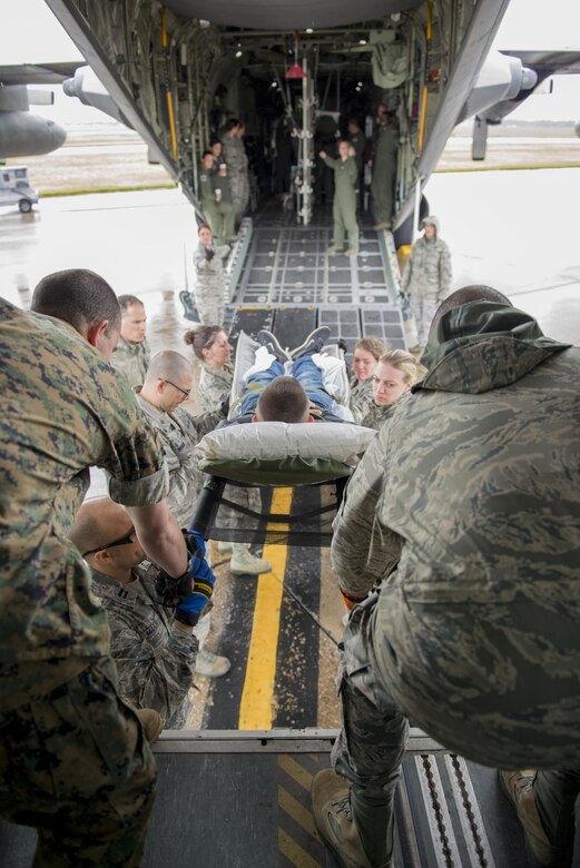 Members of the 914th Aeromedical Staging Squadron, along with other medical personnel from different branches of service, transfer a “patient” from bus to C-130 Aircraft as part of a joint service training exercise. Participants carry out simulated emergency scenarios to gain skills and experience that can be applied to real world situations. (U.S. Air Force photo by Tech. Sgt. Stephanie Sawyer) 