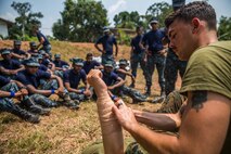 WELISARA NAVAL BASE, Sri Lanka (March 29, 2017) U.S. Navy Petty Officer 3rd Class Ryan Walker, a hospital corpsman with Battalion Landing Team 1st Bn., 4th Marines, 11th Marine Expeditionary Unit (MEU), shows Sri Lankan Marines the proper way to apply a dressing to a wound during the tactical casualty combat care portion of a military tactics training and exchange at Welissara Naval Base as part of a theater security cooperation engagement, March 29. Over the course of the engagement, Marines with the 11th MEU, alongside Marines and Sailors with the Sri Lankan Navy will take part in basic military tactics exercises, humanitarian assistance and disaster relief training, and community relations projects. (U.S. Marine Corps photo by Cpl. Devan K. Gowans)