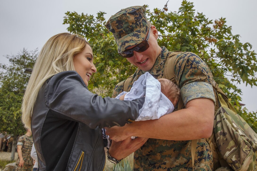 MARINE CORPS BASE CAMP PENDLETON, California (May 12, 2017) U.S. Marine Corporal Eric Burkett, a tactical switching operator with the 11th Marine Expeditionary Unit (MEU), holds his new-born son during an 11th MEU homecoming event at Camp Pendleton, Calif., May 12. Burkett held his one-month-old baby boy for the first time after a seven-month deployment throughout the Asia-Pacific and Middle East regions. After months apart, the Marines and Sailors embarked aboard the Makin Island Amphibious Ready Group reunite with their families and loved-ones. (U.S. Marine Corps photo by Sgt April L. Price)
