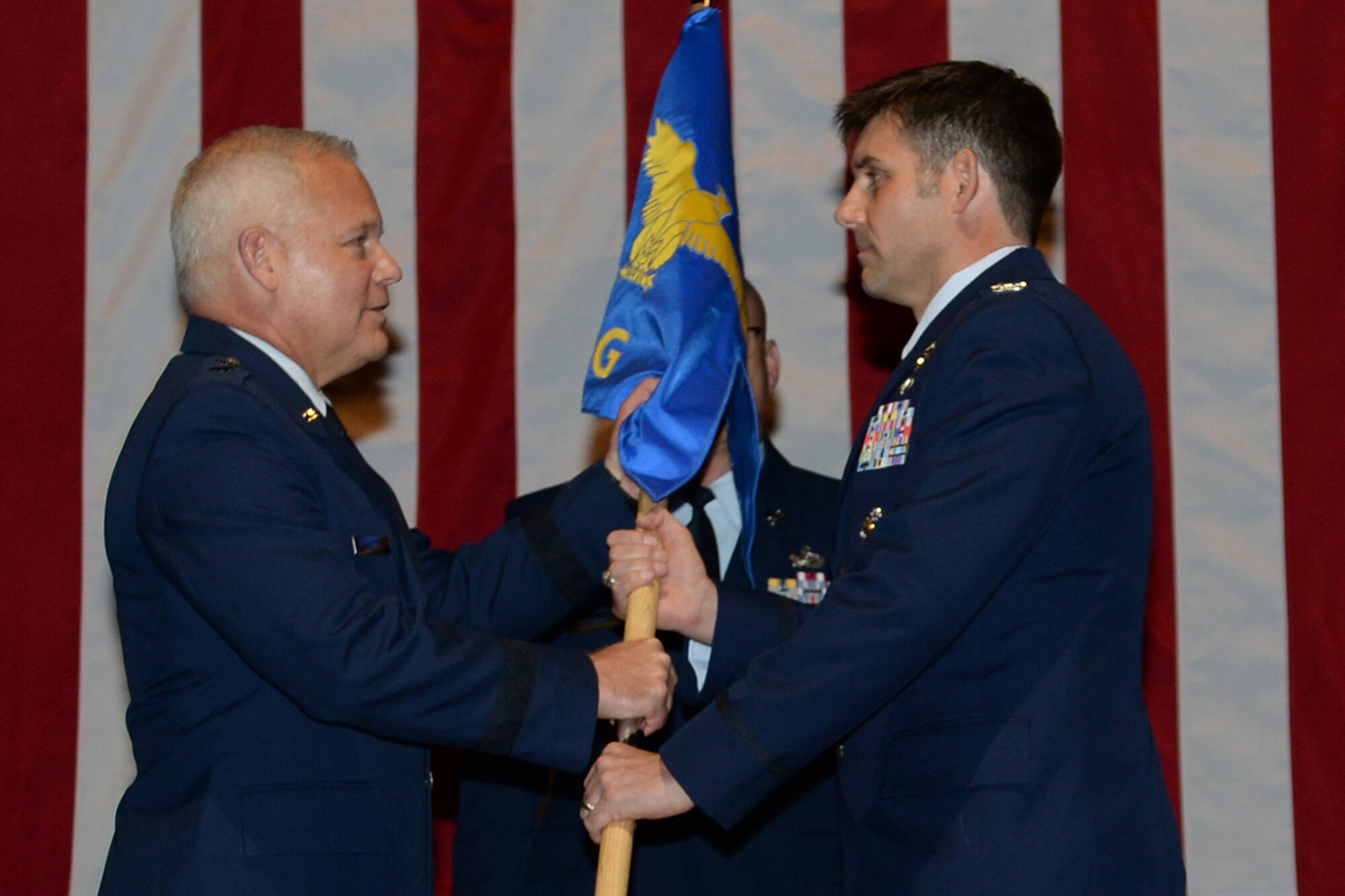 U.S. Air Force Maj. Gen. John P. Stokes, commander, 22nd Air Force, passes the guidon to Col. Christopher T. Lay during an assumption of command ceremony at Little Rock Air Force Base, Ark., June 3, 2017. Lay assumed command of the 913th Airlift Group at Little Rock AFB. (U.S. Air Force photo by Airman 1st Class Codie Collins/Released)