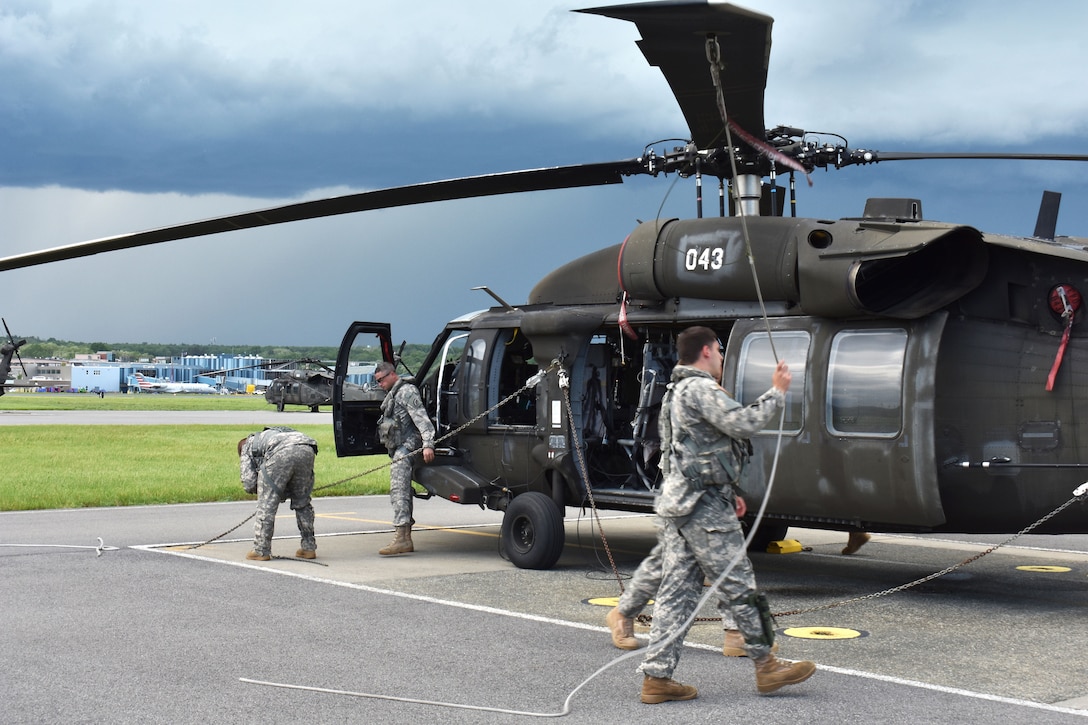 New York Army National Guard pilots and crew chiefs secure a UH-60 Black Hawk helicopter in Latham, N.Y., May 31, 2017, after training with a bucket firefighting system. Army National Guard photo by Pfc. Andrew Valenza 