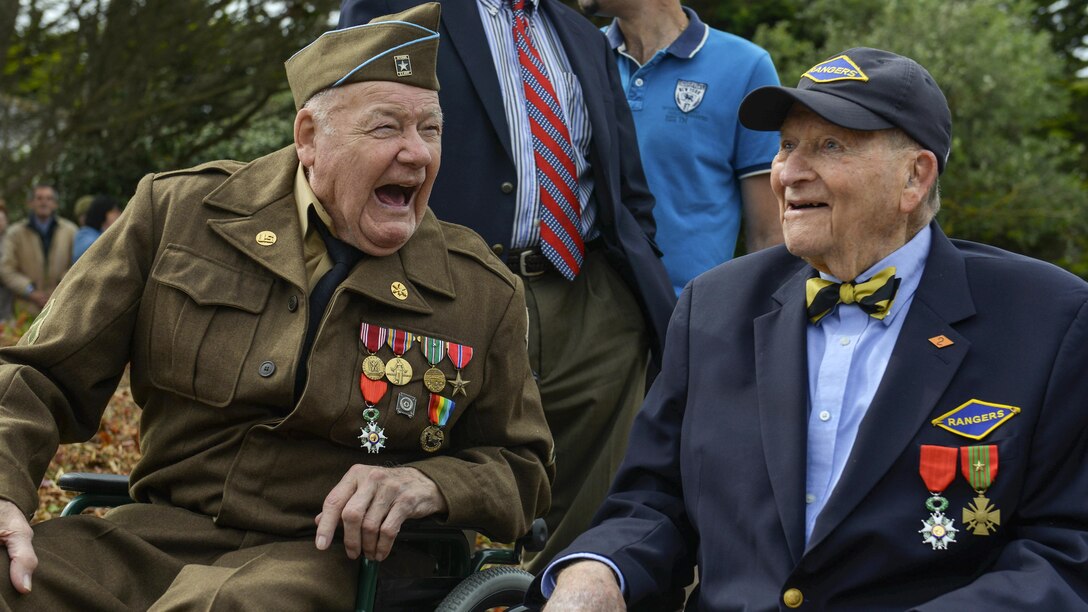 Two D-Day veterans who participated in the liberation of France share a laugh in Saint-Laurent-sur-Mer, France, June 5, 2017, while attending a ceremony to commemorate the 73rd anniversary of D-Day. DoD photo by Airman 1st Class Alexis C. Schultz