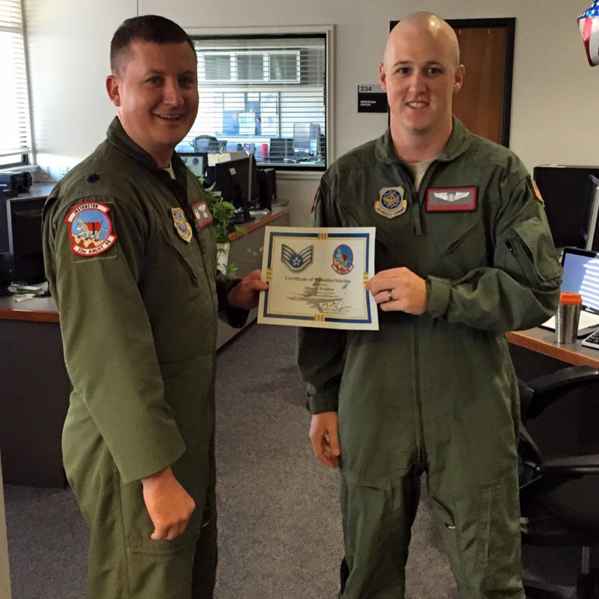 U.S. Air Force Lt. Col. Matthew Jones, the former 22nd Airlift Squadron commander, presents U.S. Air Force Staff Sgt. Oliver Broadbent, 22nd Airlift Squadron loadmaster, with a promotion certificate at Travis Air Force Base, Calif. (Courtesy photo)