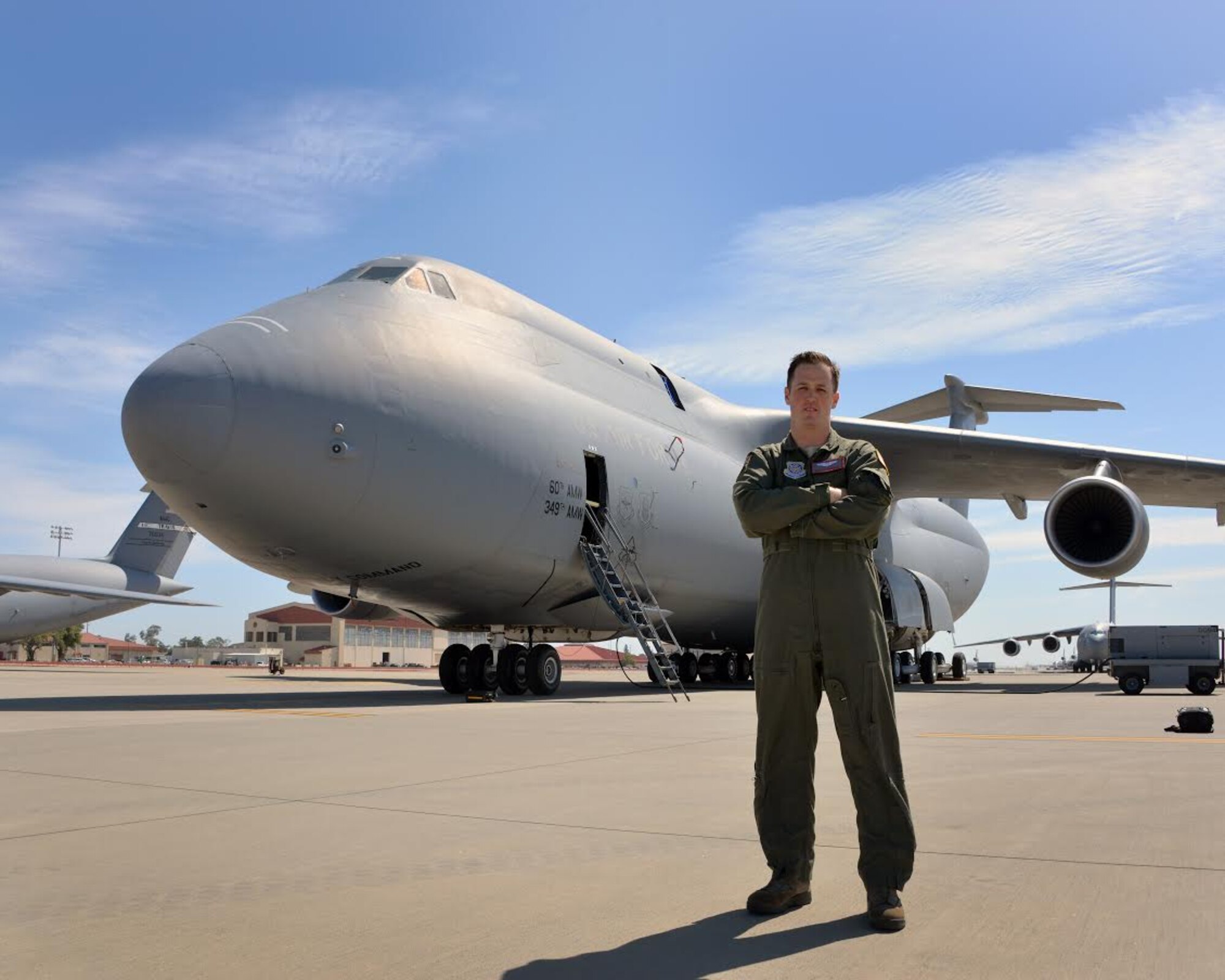 U.S. Air Force Staff Sgt. Oliver Broadbent, 22nd Airlift Squadron loadmaster, poses for a photo in front of a C-5M Super Galaxy June 6, 2017, at Travis Air Force Base, Calif. After overcoming Follicular non-Hodgkin lymphoma, it took nine additional months to regain his qualification and flying status as an Air Force loadmaster. (U.S. Air Force photo by Staff Sgt. Charles Rivezzo)  