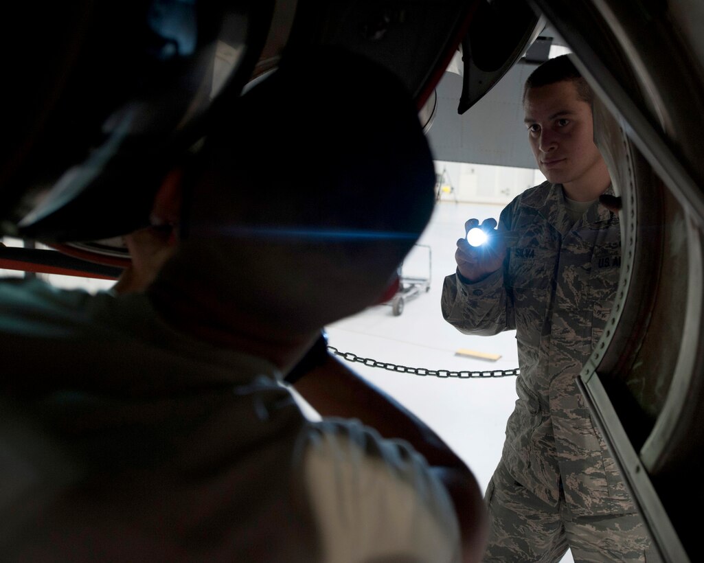 U.S. Air Force Staff Sgt. Eleno G. Silva, 317th Maintenance Squadron aerospace maintenance craftsman, monitors his coworker, U.S. Air Force Airman 1st Class Sam Houck, 317th Maintenance Squadron aerospace maintenance apprentice, inside a hangar at Dyess Air Force Base, Texas, March 30, 2017. Silva's supervision ensures the task is being done effectively, correctly and safely. (U.S. Air Force Photo by Airman Kylee Thomas)