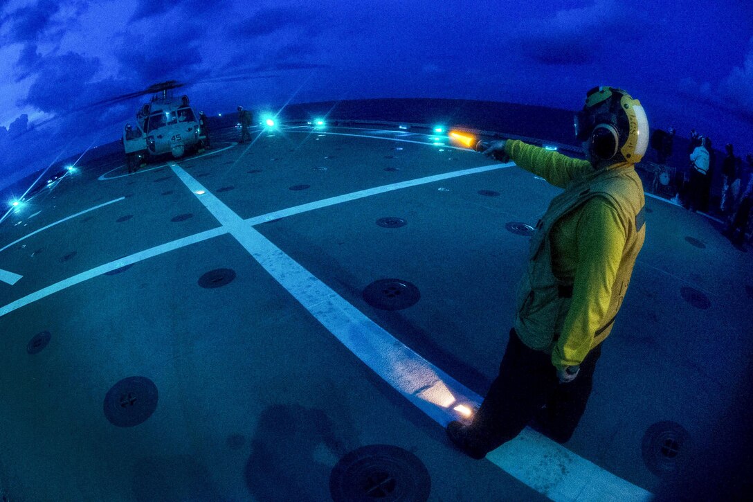 Navy Petty Officer 1st Class Alishia Miller signals to the pilots of an MH-60S Seahawk helicopter aboard the USS Coronado in the Gulf of Thailand, June 2, 2017, during flight operations as part of the annual Cooperation Afloat Readiness and Training Thailand exercise. Navy photo by Petty Officer 3rd Class Deven Leigh Ellis