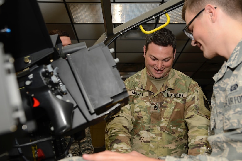 U.S. Army Staff Sgt. Adam Arafat, 128th Aviation Brigade instructor, shows U.S. Air Force Airman Tyler Barlow, 633rd Force Support Squadron force management apprentice, the inner-workings of a an AH-64 Apache helicopter during a tour at Joint Base Langley-Eustis, Va. June 2, 2017. The tour offered Airmen, assigned to the 633rd FSS, a chance to see what life is like as a 128th Avn. Bde. Advanced Individual Training student. (U.S. Air Force photo/Airman 1st Class Kaylee Dubois)
