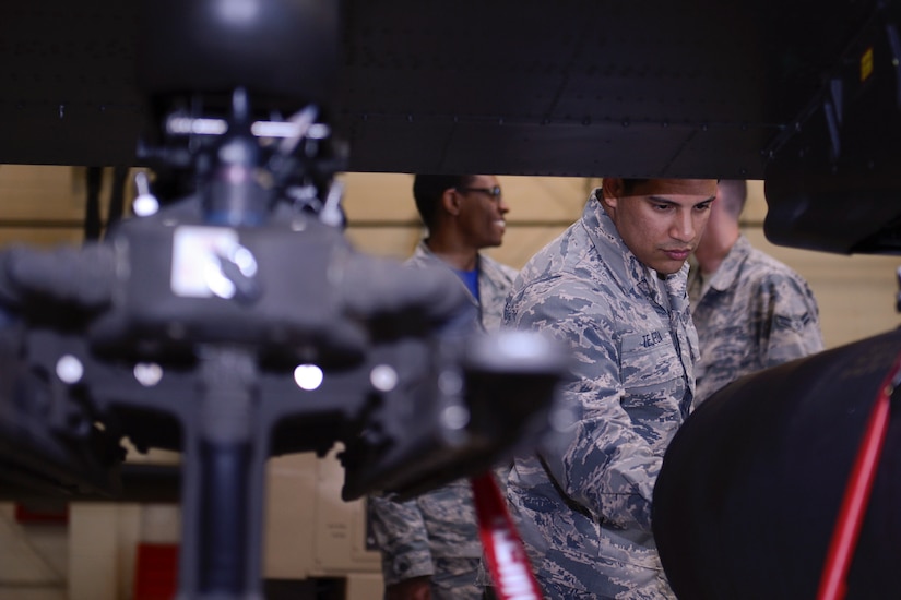 U.S. Air Force Airman 1st Class Caesar Tejeda, 633rd Force Support Squadron career development specialist, explores the weapon systems unit on an AH-64 Apache helicopter during a tour of the 128th Aviation Brigade at Joint Base Langley-Eustis, Va. June 2, 2017. Throughout the tour, the 633rd FSS Airmen were introduced to the different training models provided to the U.S. Army 128th Avn. Bde. Advanced Individual Training students, such as the large-scale helicopter models used for hands-on training. (U.S. Air Force photo/Airman 1st Class Kaylee Dubois)