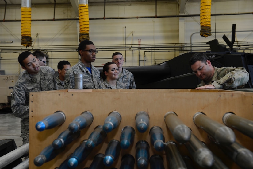 U.S. Army Staff Sgt. Adam Arafat, 128th Aviation Brigade instructor, explains to U.S. Air Force Airmen, assigned to the 633rd Force Support Squadron, the high explosive weapons used by theAH-64 Apache helicopter during a tour of the 128th Aviation Brigade at Joint Base Langley-Eustis, Va. June 2, 2017. During the tour, Airmen observed the advanced technology used to train U.S. Army helicopter maintainers. (U.S. Air Force photo/Airman 1st Class Kaylee Dubois)