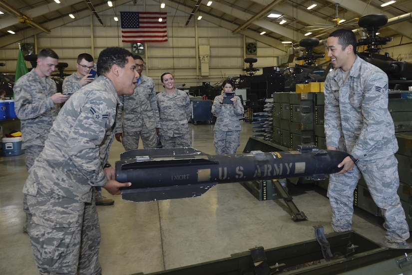 U.S. Air Force Airman 1st Class Caesar Tejeda and Senior Airman Colin Smith, 633rd Force Support Squadron personnel, lift a training explosive device during a tour of the 128th Aviation Brigade at Joint Base Langley-Eustis, Va. June 2, 2017. The tour provided the Airmen with the opportunity to see how helicopter maintenance contributes to joint force efforts around the world. (U.S. Air Force photo/Airman 1st Class Kaylee Dubois)