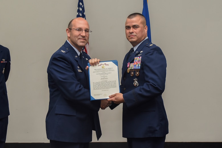 U.S. Air Force Col. Christopher Harris, 17th Mission Support Group Commander, presents a Meritorious Service certificate to Maj. Pedro Jimenez, 17th Security Forces Squadron commander, at the Event Center on Goodfellow Air Force Base, Texas, June 5, 2017. The event honored Jimenez’ service and welcomed its new commander Maj. Min Lee. (U.S. Air Force photo by Airman 1st Class Chase Sousa/Released)