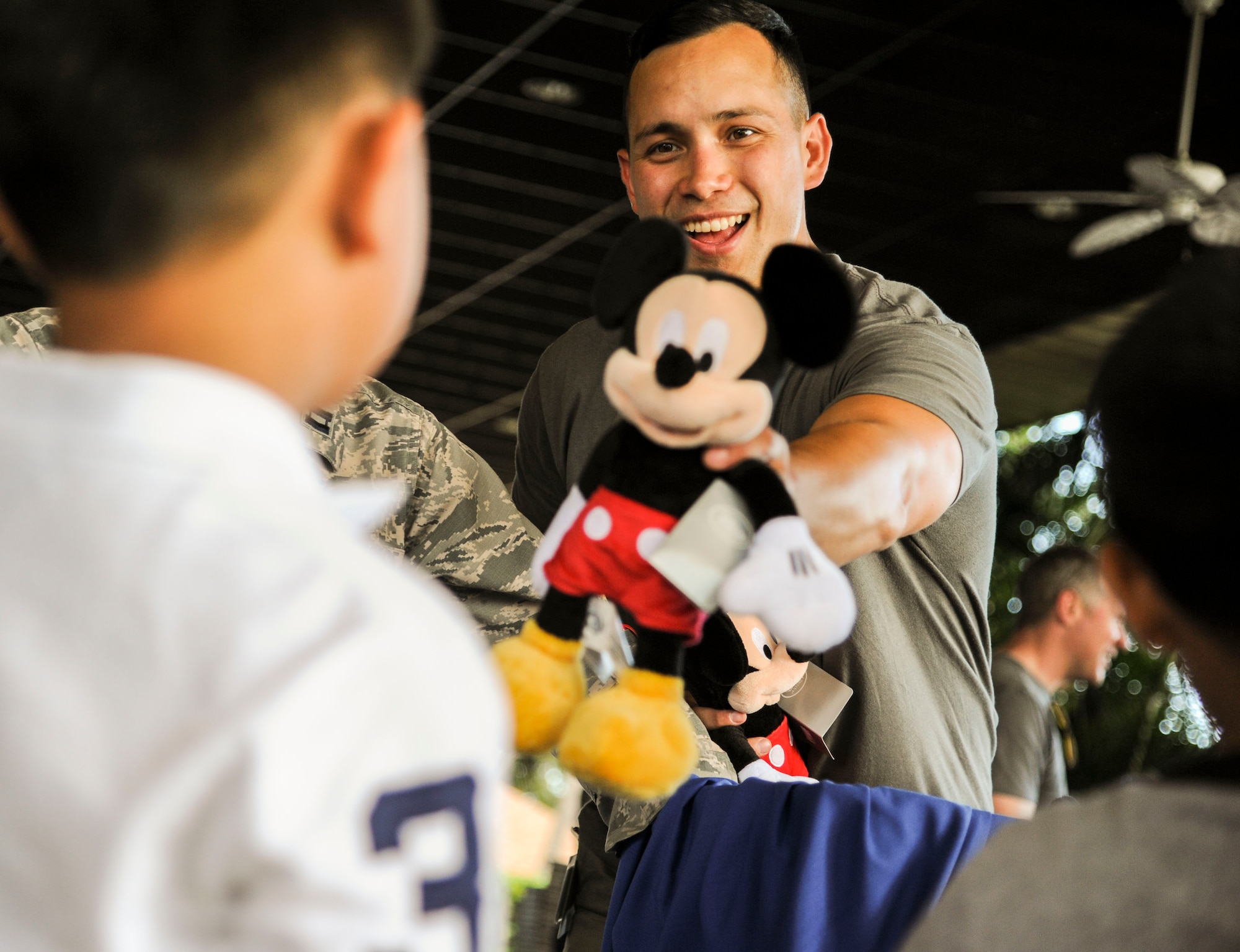 U.S. Air Force Staff Sgt. Christopher Stoltz, 647th Air Base Group photojournalist, hands out stuffed Mickey Mouses during the Books on Bases event at the Hickam Officers Club, hosted by Blue Star Families, Joint Base Pearl Harbor-Hickam, Hawaii, June 2, 2017.  Blue Star Families program donates books to military children, base libraries, Department of Defense schools, and military-impacted public schools and libraries across the world. (U.S. Air Force photo by Tech. Sgt. Heather Redman)