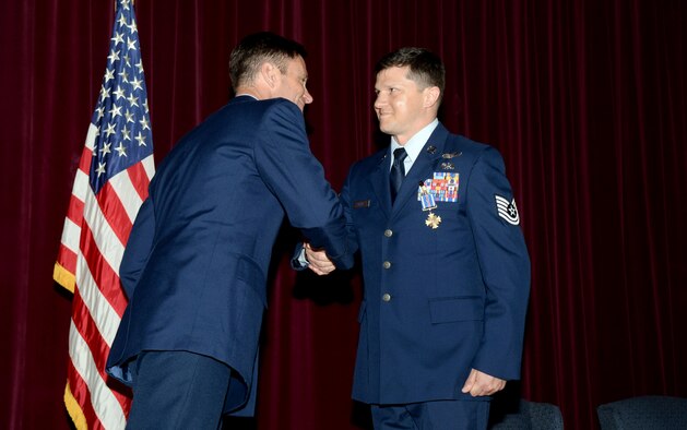 U.S. Air Force Col. Matthew D. Smith, left, 352d Special Operations Wing commander, presents U.S. Air Force Tech. Sgt. James M. McKay, right, 7th Special Operations Squadron special missions’ aviator, with the Distinguished Flying Cross medal June 2, 2017, on RAF Mildenhall, England. McKay is the 80th Airman in Air Force Special Operations Command to receive this honor, a medal created in 1918 to reward those who display heroism or extraordinary achievement while participating in an aerial flight. (U.S. Air Force photo by Airman 1st Class Tenley Long)