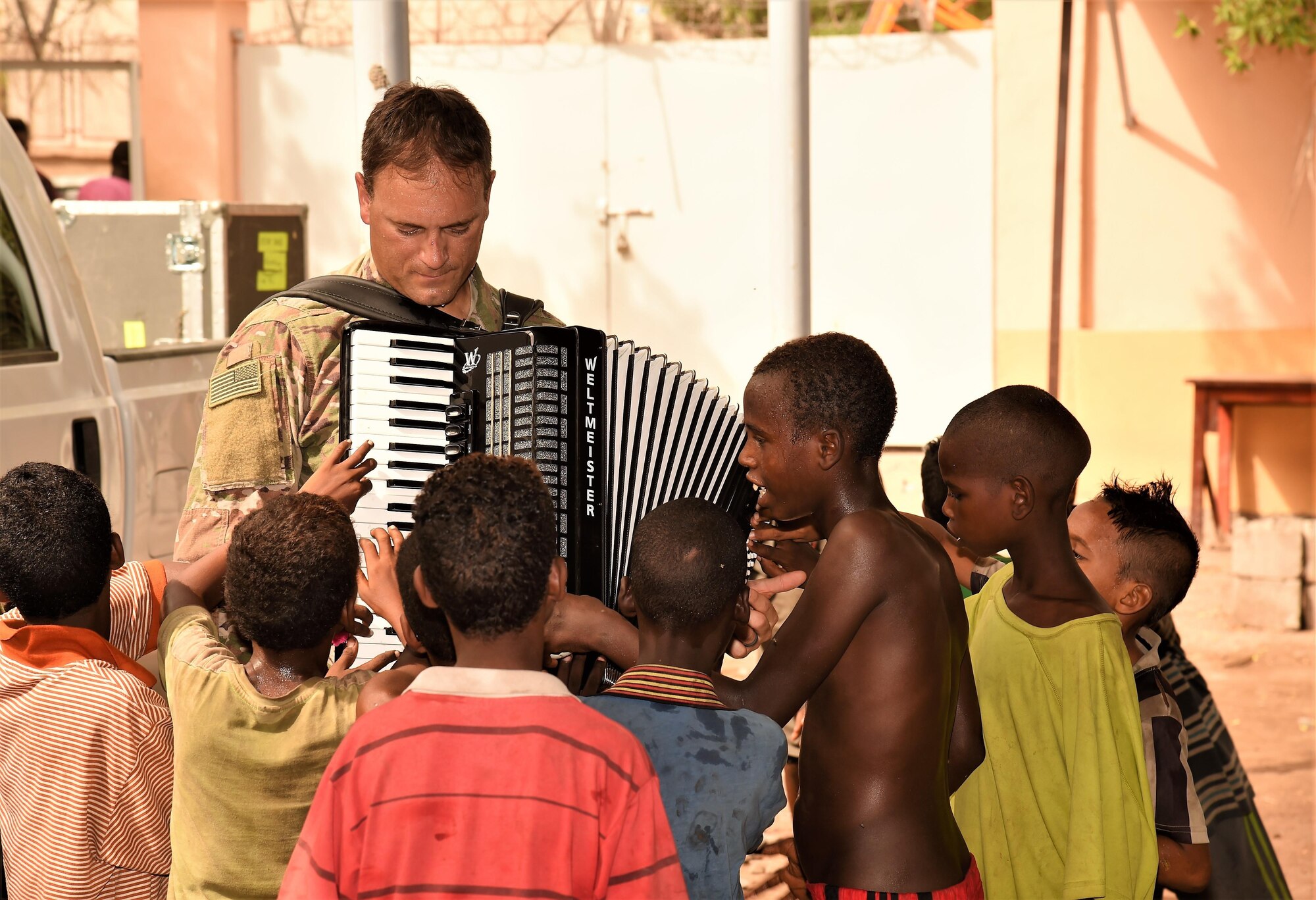 Airman 1st Class Anneke Bentley, U.S. Air Forces Central Command Band vocalist, sings and dances with a child from Caritas Djibouti while Airman 1st Class Joshua Dick, AFCENT Band percussionist, and Tech. Sgt. Joshua Holdridge, AFCENT Band bass player, accompany her in Djibouti City, June 6, 2017. The AFCENT Band, Starlifter, is based in Al Udeid Air Base, Qatar, and has a mission of performing and touring in small ensembles to positively promote troop morale, diplomacy and outreach to host nation communities. (U.S. Air National Guard photo by Tech. Sgt. Andria Allmond)
