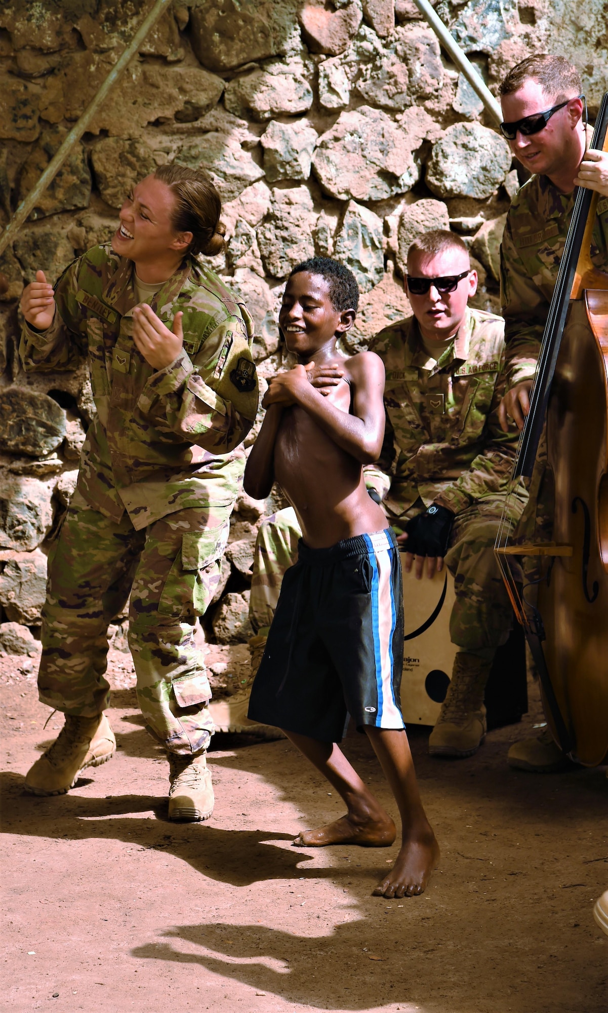 Airman 1st Class Anneke Bentley, U.S. Air Forces Central Command Band vocalist, sings and dances with a child from Caritas Djibouti while Airman 1st Class Joshua Dick, AFCENT Band percussionist, and Tech. Sgt. Joshua Holdridge, AFCENT Band bass player, accompany her in Djibouti City, June 6, 2017. The AFCENT Band, Starlifter, is based in Al Udeid Air Base, Qatar, and has a mission of performing and touring in small ensembles to positively promote troop morale, diplomacy and outreach to host nation communities. (U.S. Air National Guard photo by Tech. Sgt. Andria Allmond)