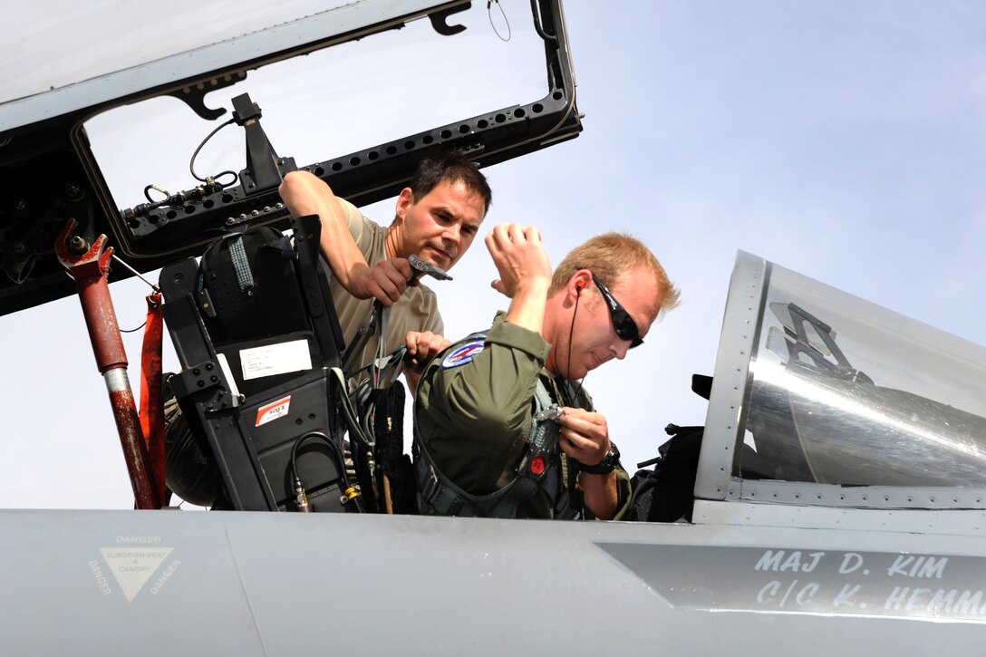 Oregon Air National Guard Master Sgt. Ryan Johannes, left, assists Capt. Joshua Pfeifer as he prepares for a sortie at Nellis Air Force Base, Nev., May 31, 2017. Pfeifer is a pilot assigned to the 123rd Fighter Squadron. Johannes is a crew chief assigned to the 142nd Fighter Wing. Air National Guard photo by Master Sgt. John Hughel