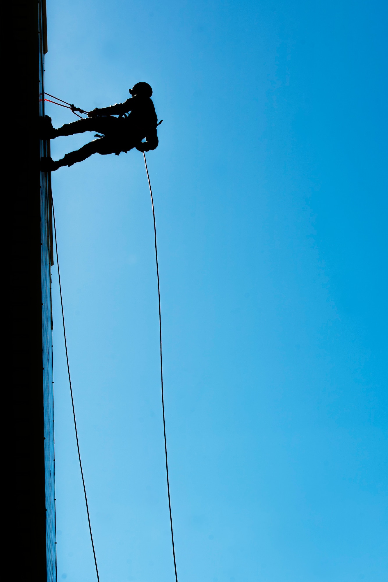 An Airman from the 5th Civil Engineer Squadron rappels down a building during an Expeditionary Training Day at Minot Air Force Base, N.D., June 1, 2017. More than 60 CE Airmen participated in the training, which consisted of an array of deployment readiness tasks. (U.S. Air Force photo/Senior Airman J.T. Armstrong)