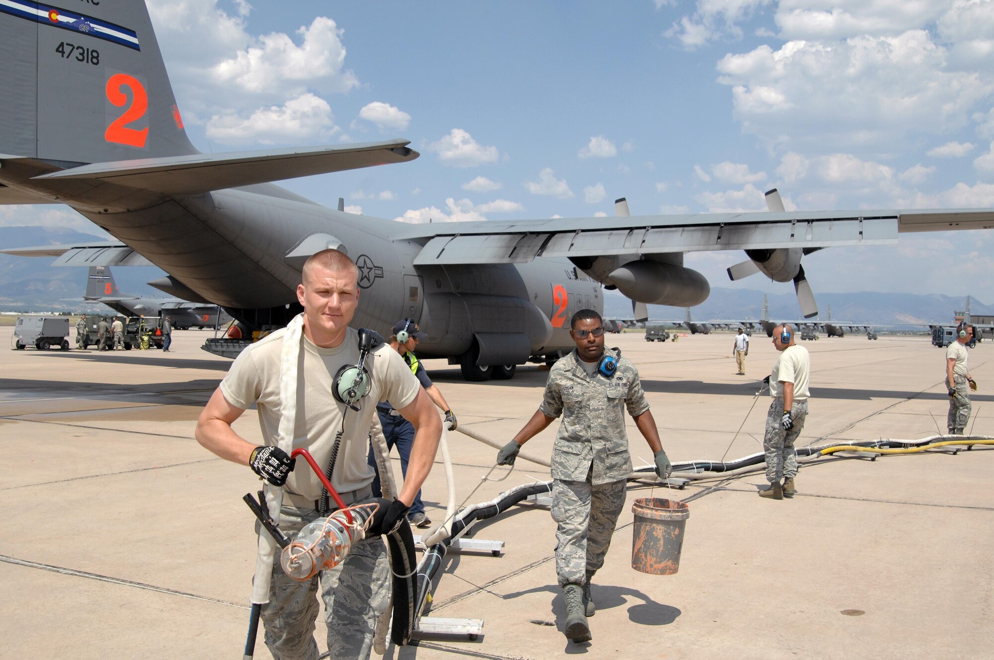 Then Senior Airmen Dustin Johannsen and Barry Logan pull a retardant hose from a MAFFS-equipped C-130 preparing to fly a drop mission in support of Colorado wildland fire fighting efforts June 29, 2012 at Peterson Air Force Base, Colo. Johannsen graduated from the U.S. Air Force Academy May 24, 2017 after applying to the Leaders Encouraging Airman Development program. (U.S. Air Force photo/Tech. Sgt. Thomas Doscher) 