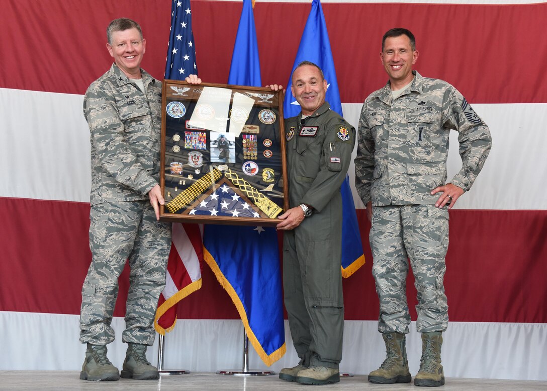 Col. Bryan Cook, 944th Fighter Wing commander, and Chief Master Sgt. James Nudd, 944 FW interim command chief, present (Ret.) Col. Kurt Gallegos, 944 FW former commander, with a shadow box June 3 during a retirement ceremony at Luke Air Force Base, Arizona. (U.S. Air Force photo by Staff Sgt. Lausanne Kinder)