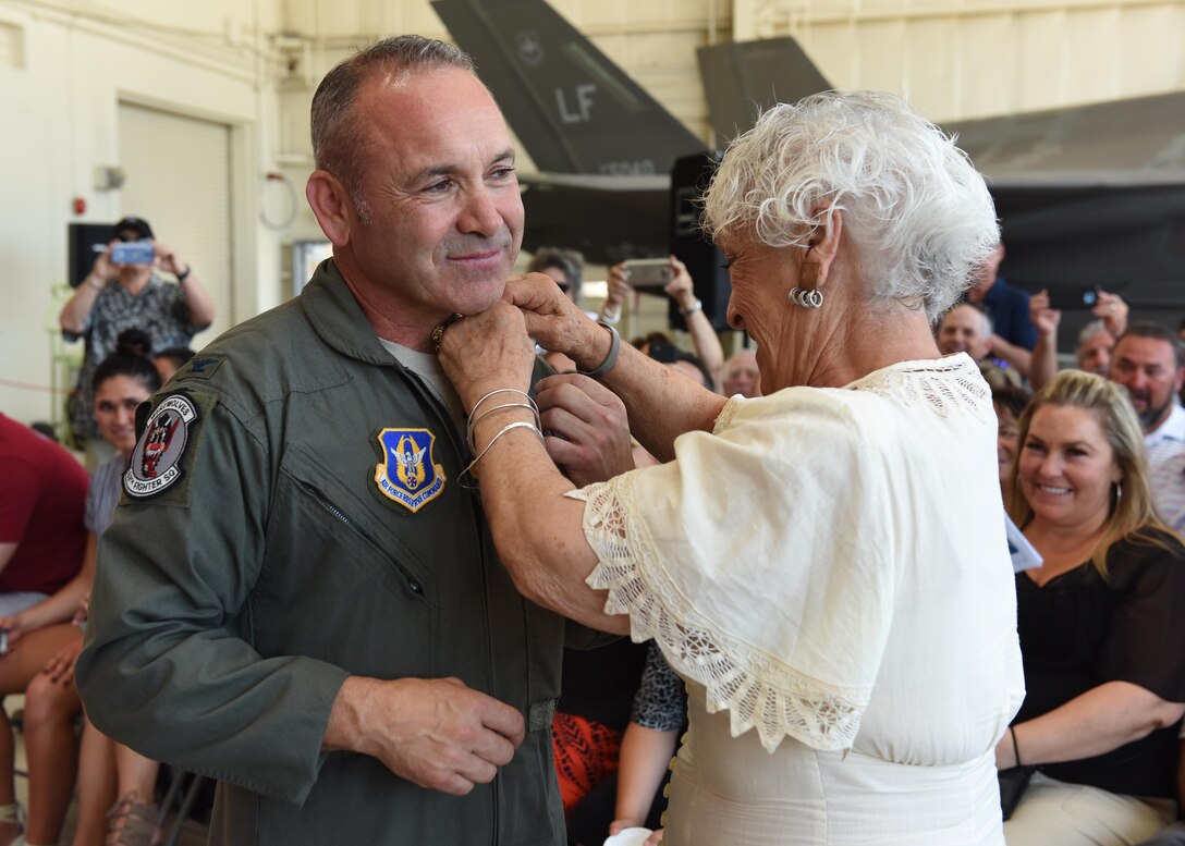 (Ret.) Col. Kurt Gallegos, 944th Fighter Wing former commander, stands while Elvia Gallegos, his mother, pins on his retirement pin June 3 during a retirement ceremony at Luke Air Force Base, Ariz. (U.S. Air Force photo by Staff Sgt. Lausanne Kinder)