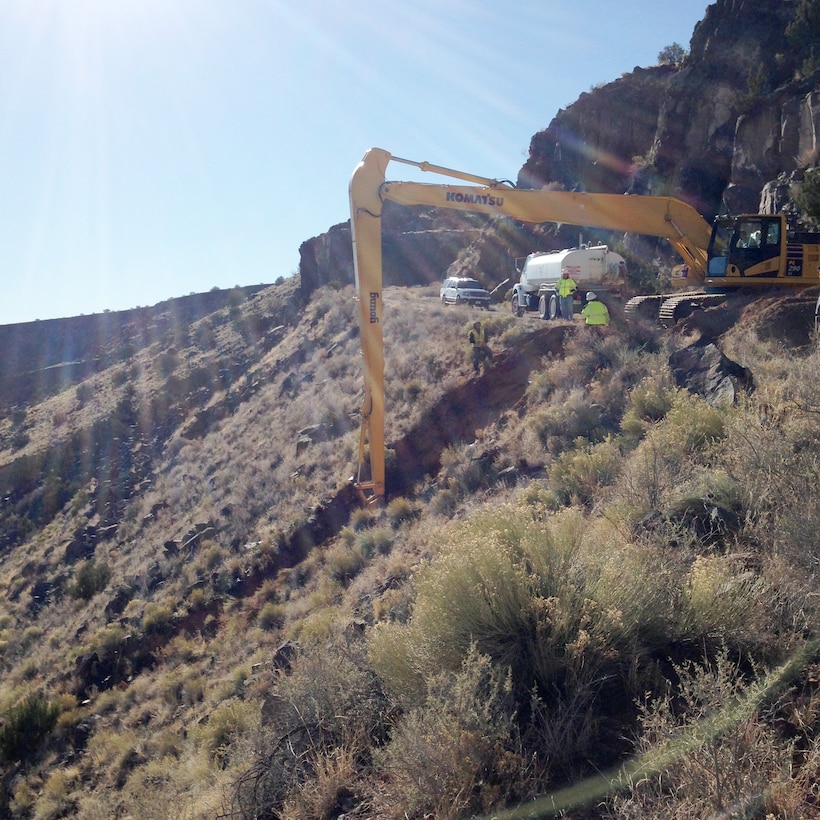 JEMEZ DAM, N.M. – Due to concerns that moving equipment into the area downslope of the culvert might damage cultural resources, the BLM crew used long-reach equipment from above to repair the culvert, Mar. 1, 2017. 