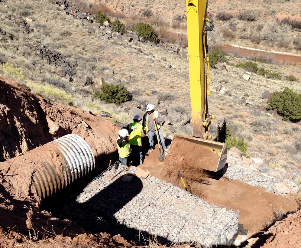 JEMEZ DAM, N.M. – Due to concerns that moving equipment into the area downslope of the culvert might damage cultural resources, the BLM crew used long-reach equipment from above to repair the culvert, Mar. 2, 2017. 