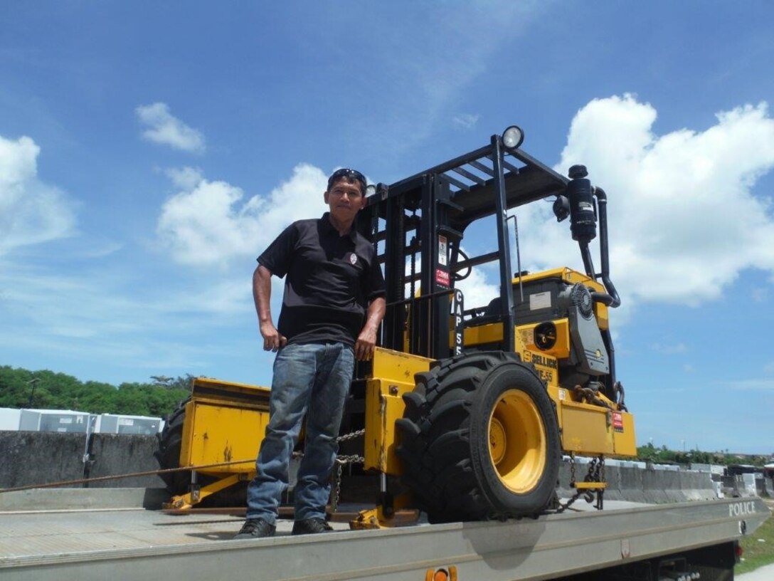 A member of the Guam Police Department prepares to transport the former military forklift his department received for use lifting barriers and placing damaged patrol cars on trailers for transport to the repair facility. 