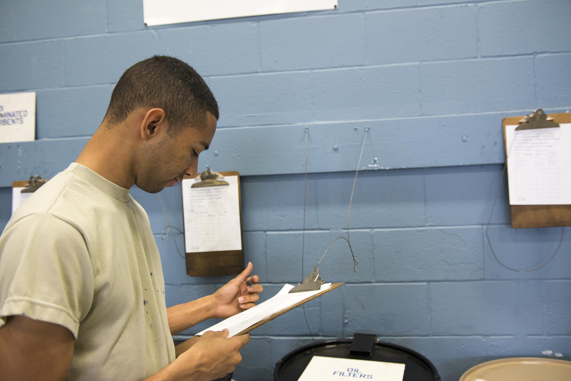 U.S. Air Force Airman Nathan Bernard, 7th Equipment Maintenance Squadron aerospace ground equipment craftsman, reads through a used oil filter container log at an Initial Accumulation Point (IAP) at Dyess Air Force Base, Texas, May 3, 2017. An IAP is an area a shop must designate to containerize and manage their hazardous waste. (U.S. Air Force photo by Senior Airman Austin Mayfield)