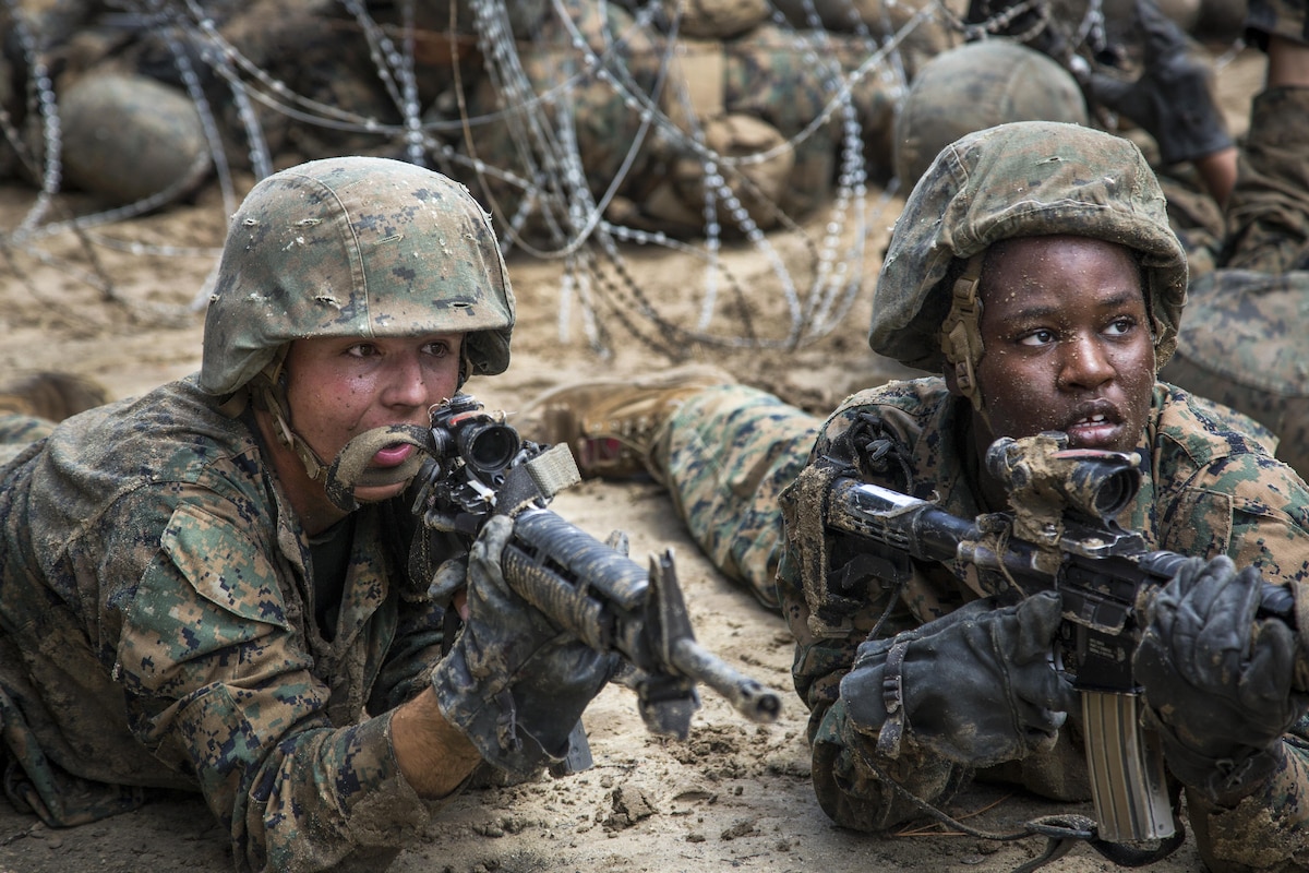 Marine Corps recruits aim weapons as they post security during basic training.