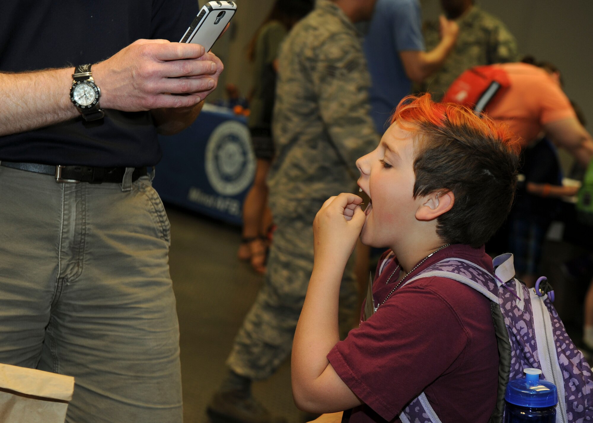 A child eats an insect at the Survival, Evasion, Resistance and Escape booth during Operation Heroes at Minot Air Force Base, N.D., June 3, 2017. During the event, children tasted Meals Ready-to-Eat, tried on gear, saw weapons displays and created custom-made dog tags. The event concluded with a redeployment line and a welcome home celebration. (U.S. Air Force photos/Senior Airman Sahara L. Fales)