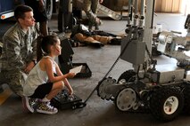 Airman 1st Class Michael Hosfield, 5th Civil Engineer Squadron explosive ordnance disposal apprentice, helps a child control an EOD robot during Operation Heroes at Minot Air Force Base, N.D., June 3, 2017. During the event, children tasted Meals Ready-to -Eat, tried on gear, saw weapons displays and created custom-made dog tags. The event concluded with a redeployment line and a welcome home celebration. (U.S. Air Force photo/Senior Airman Sahara L. Fales)