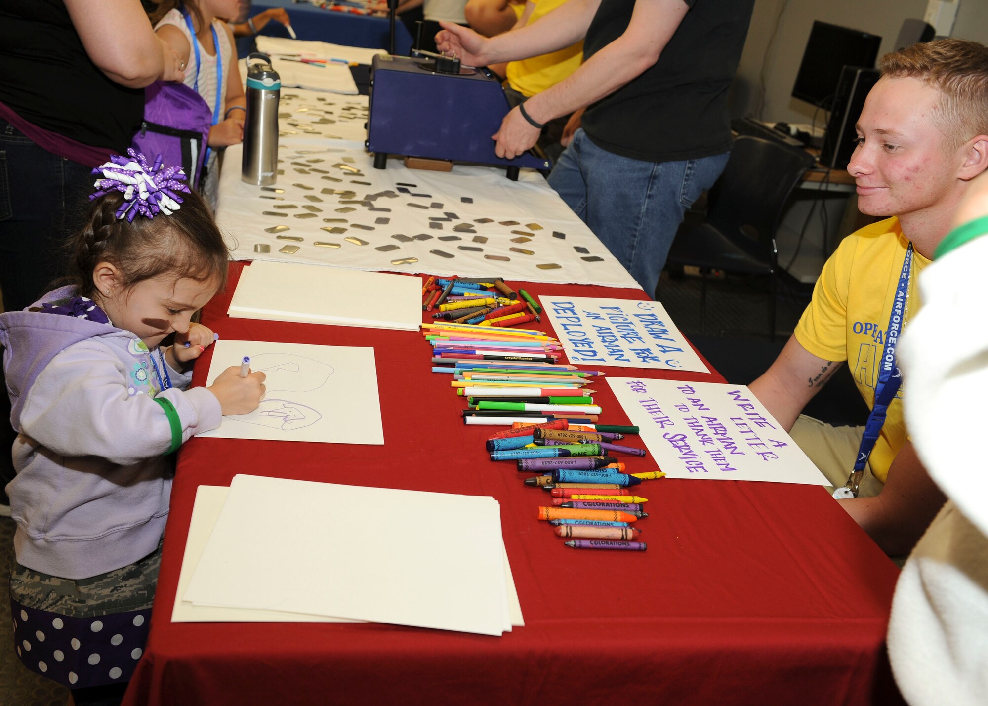 A child colors a picture during Operation Heroes at Minot Air Force Base, N.D., June 3, 2017. During the event, children tasted Meals Ready-to-Eat, tried on gear, saw weapons displays and created custom-made dog tags. The event concluded with a redeployment line and a welcome home celebration. (U.S. Air Force photo/Senior Airman Sahara L. Fales)