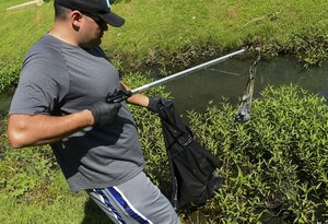 U.S. Air Force Tech. Sgt. Joshua Patterson, 1st Maintenance Group weapons standardization lead crew member, gathers trash during the annual Clean the Bay Day at Joint Base Langley-Eustis, Va., June 3, 2017. This year marked the 29th annual Clean the Bay Day for JBLE. (U.S. Air Force photo/Senior Airman Derek Seifert)
