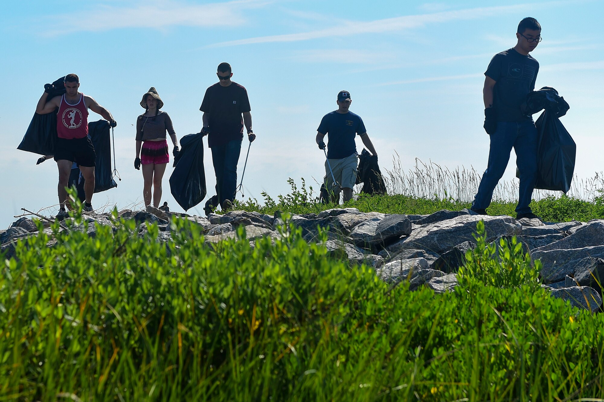 Volunteers gather trash along the shoreline during the 29th annual Clean the Bay Day at Joint Base Langley-Eustis, Va., June 3, 2017. Since 1989, JBLE members have contributed to the removal of 6.4 million pounds of debris from nearly 6,900 miles of shoreline in Virginia during Clean the Bay Days. (U.S. Air Force photo/Senior Airman Derek Seifert)