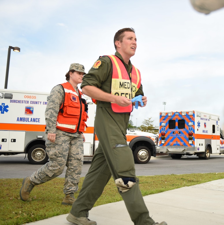 Capt. Dannielle Yuen, left, 628th Medical Group team chief of patient support, and Capt. Randall Yale, 628th Medical Group casualty management officer, arrive on scene at Dorchester County’s mass casualty at Ashley Ridge High School in Summerville, S.C., June 6, 2017. Joint Base Charleston assisted multiple Dorchester County emergency response agencies during the community partnered exercise. The event aimed to improve interagency communication and response to large scale emergencies.