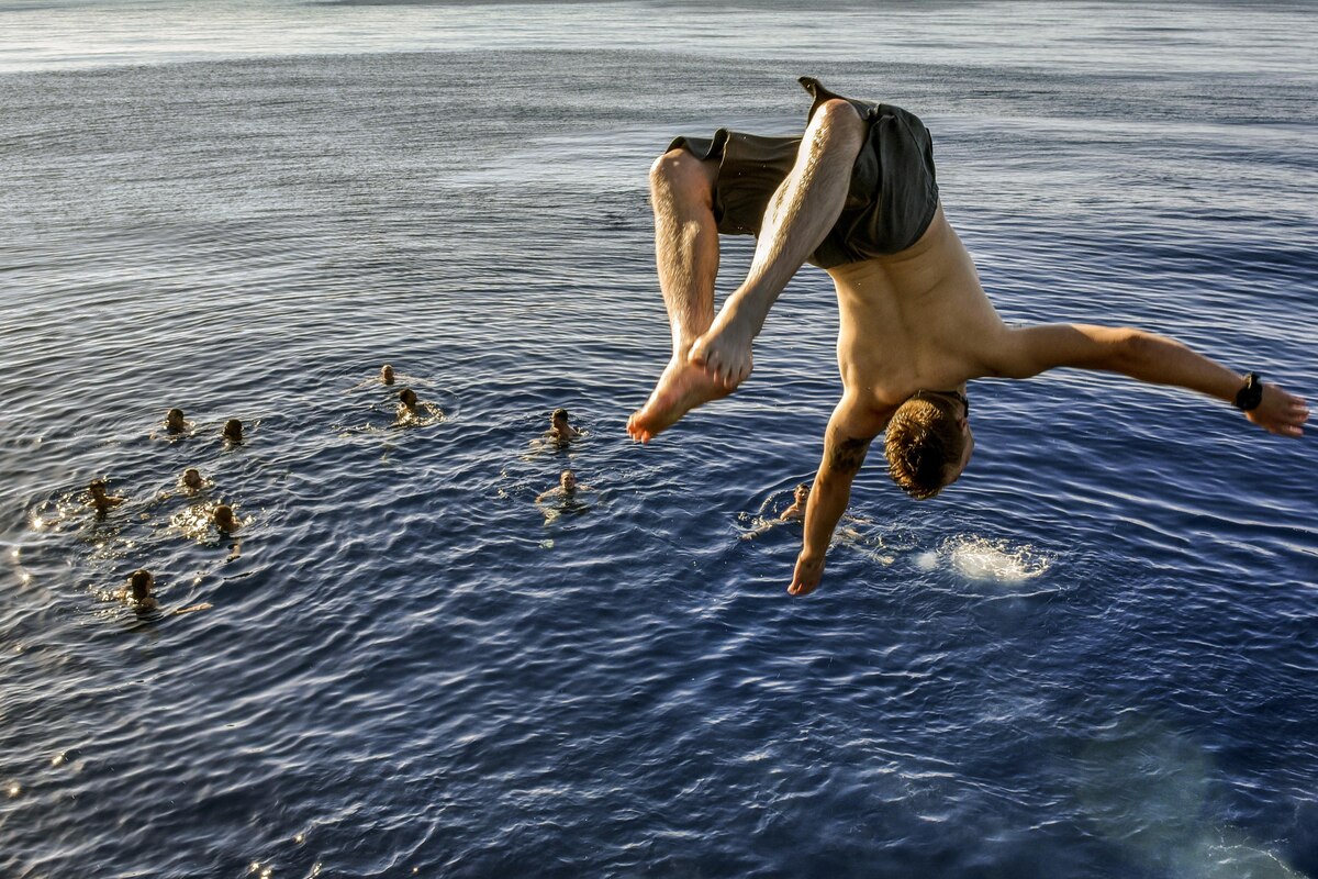 A sailor performs a backflip off a ship into the Mediterranean Sea.