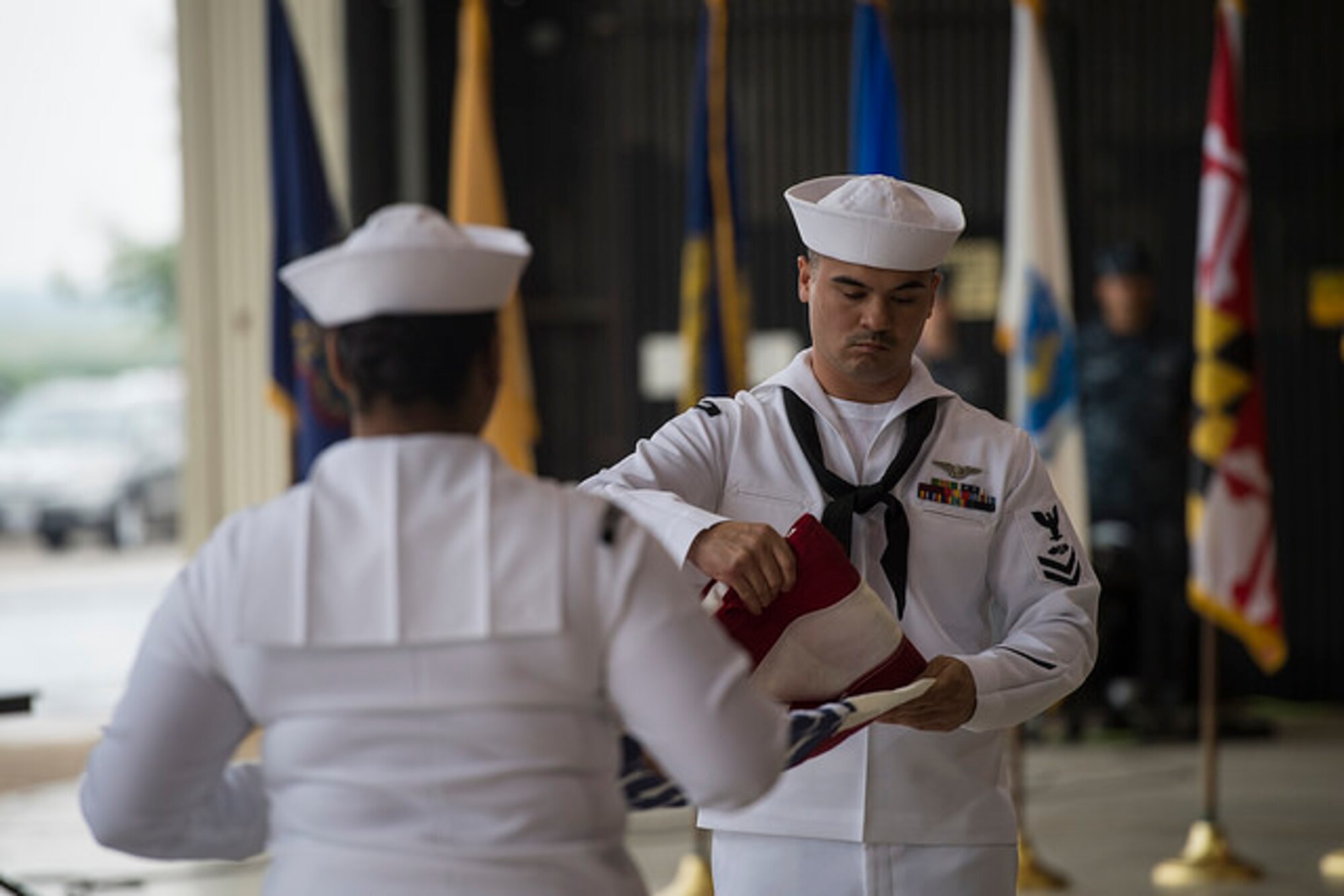 Sailors from Naval Support Activity Lakehurst, fold a flag during the Battle of Midway commemoration ceremony at Joint Base McGuire-Dix-Lakehurst, N.J. June 5. The Battle of Midway occurred 75 years ago.