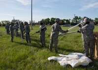 Airmen from the 5th Civil Engineer Squadron pass tent pillars at Minot Air Force Base, N.D., June 1, 2017. Approximately 60 Airmen participated in Expeditionary Training Day. (U.S. Air Force photo/Airman 1st Class Alyssa M. Akers)