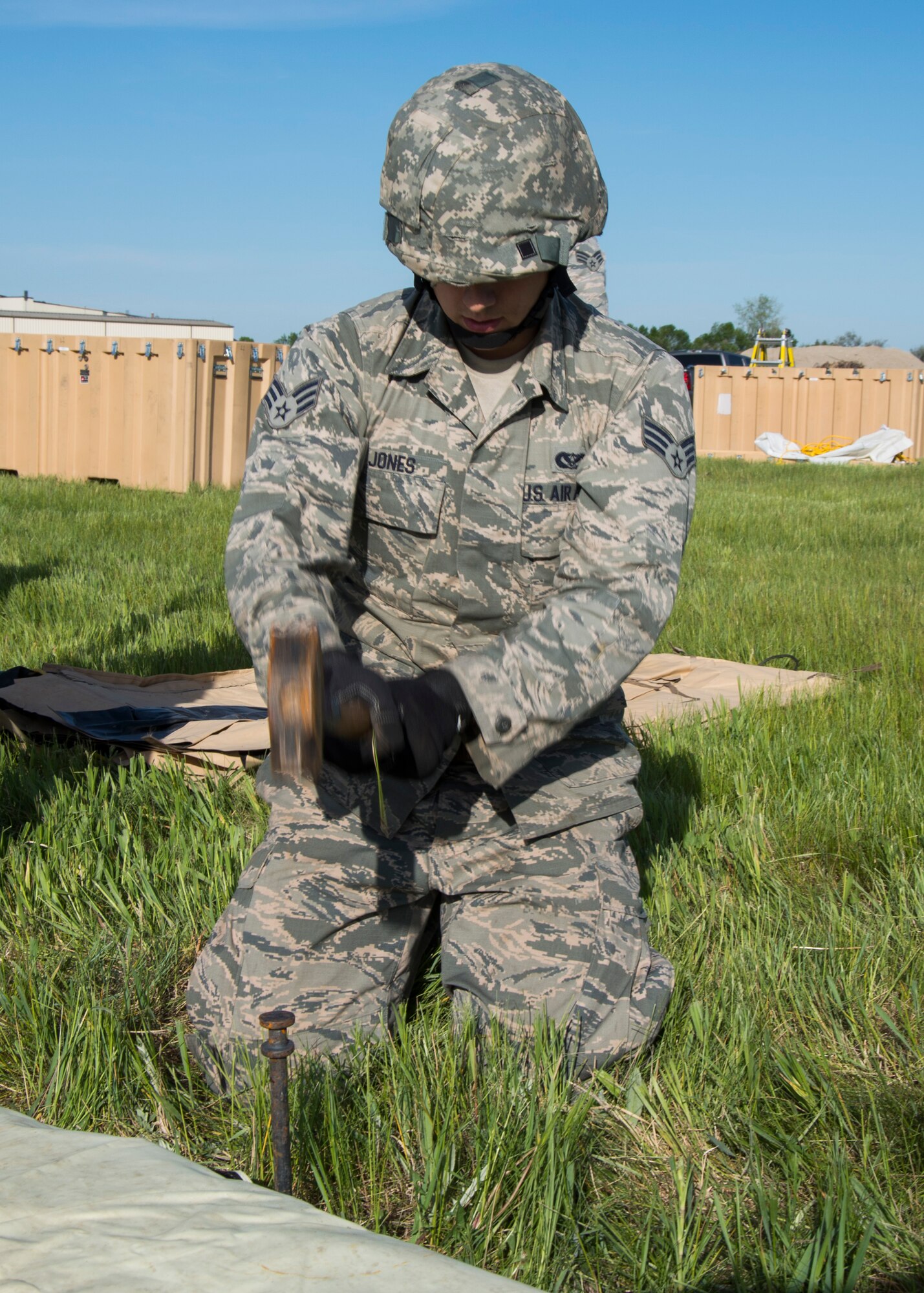 Senior Airman John Jones, 5th Civil Engineer Squadron structural apprentice, hammers a stake into the ground at Minot Air Force Base, N.D., June 1, 2017. The 5th CES built two tents during Expeditionary Training Day to help Airmen prepare for potential deployment. (U.S. Air Force photo/Airman 1st Class Alyssa M. Akers)